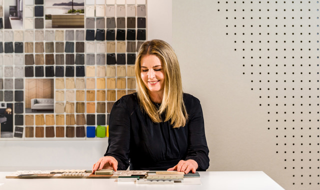 Interior designer smiling while reviewing the finishes and samples for a current workplace project